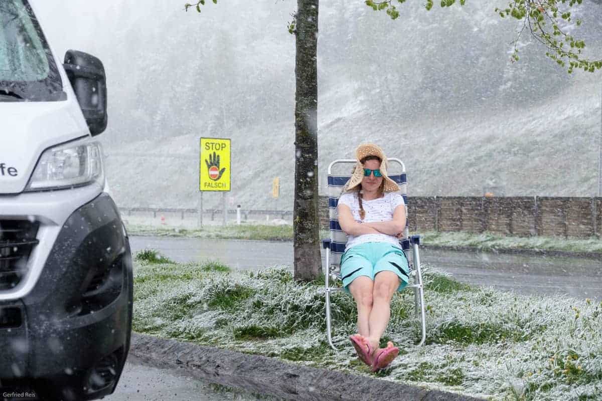 Neben Wohnmobil im Schnee sitzen