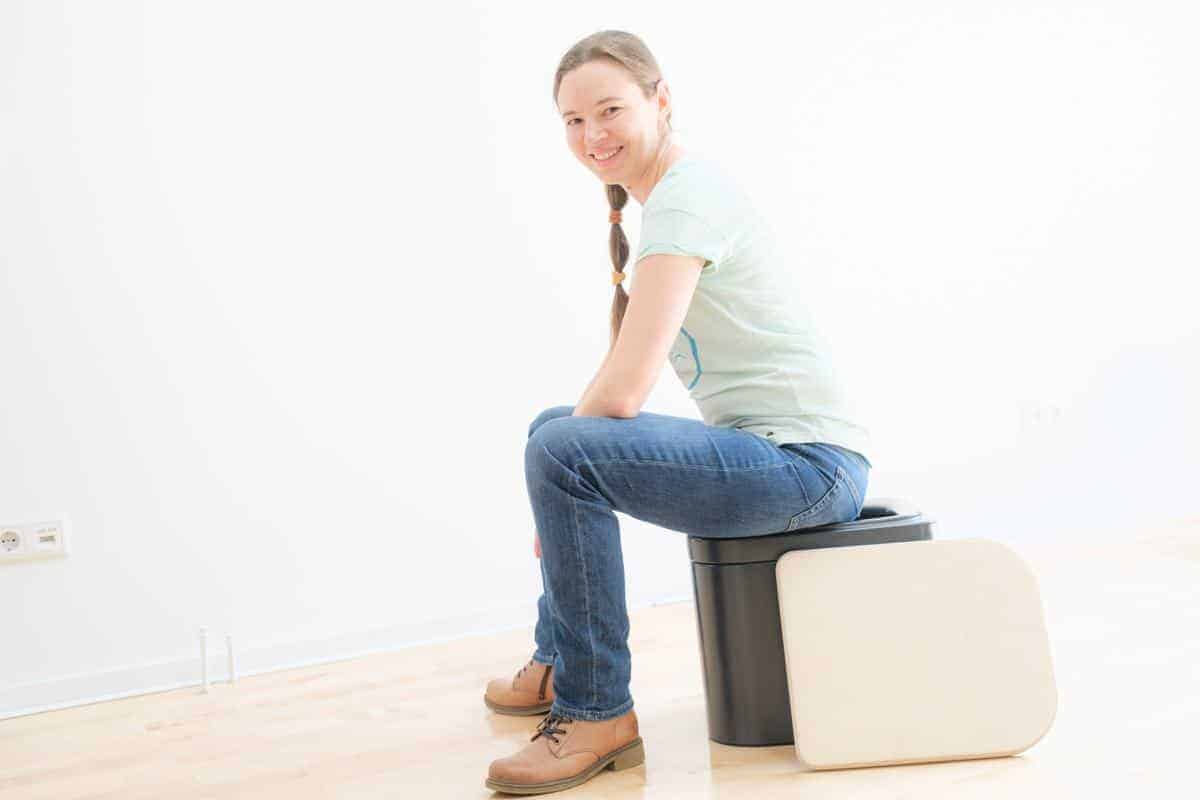 Frau auf Trockentrenntoilette