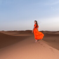 Frau in rotem Kleid in der Sahara Frau in rotem Kleid in der Sahara